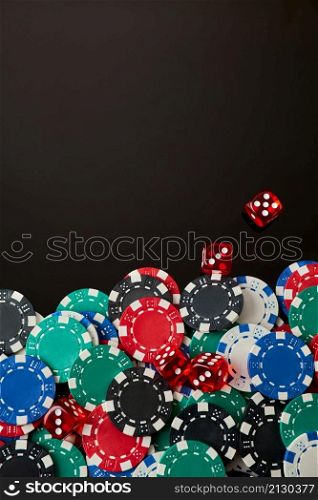 Frame made of Casino chips and dices on dark reflective background with copy space.. Frame made of Casino chips and dices on dark reflective background with copy space