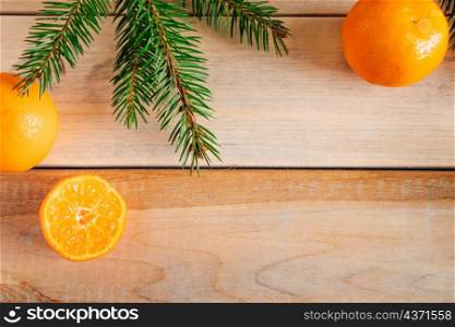 Frame made of fir branches and tangerines on a wooden background. Christmas decor. Place for text.. Frame made of fir branches and tangerines on wooden background. Christmas decor.