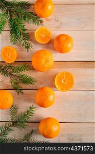 Frame made of fir branches and tangerines on a wooden background. Christmas decor. Place for text.. Frame made of fir branches and tangerines on wooden background. Christmas decor.