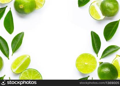 Frame made of fresh limes with green leaves on white background. Copy space