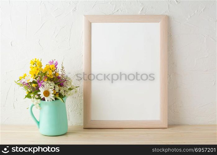 Frame mockup with tender flowers in mint green vase. Poster white frame mockup. Empty white frame mockup for presentation design.. Frame mockup with flowers in mint green vase