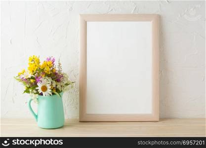 Frame mockup with tender flowers in mint green vase. Poster white frame mockup. Empty white frame mockup for presentation design.. Frame mockup with flowers in mint green vase