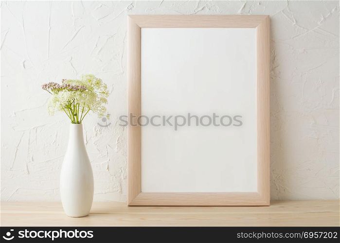 Frame mockup with tender flowers in white stylish vase . Frame mockup with tender flowers in white stylish vase. Poster white frame mockup. Empty white frame mockup for presentation design.
