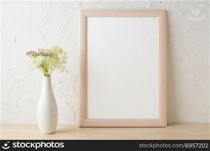 Frame mockup with tender flowers in white stylish vase . Frame mockup with tender flowers in white stylish vase. Poster white frame mockup. Empty white frame mockup for presentation design.