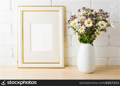Frame mockup with wild flowers bouquet. Frame mockup with wild flowers bouquet. Portrait or poster white frame mockup. Empty white frame mockup for presentation artwork.