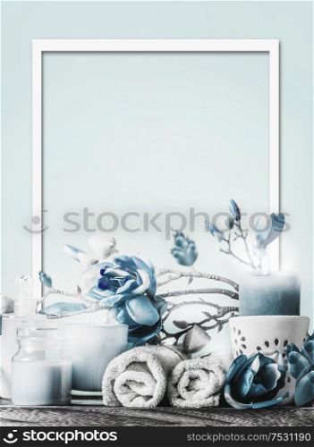 Frame of blue white spa and wellness setting. Pastel colors. Cosmetics and burning candles. Towels and flowers. Beauty layout. Body care essentials.