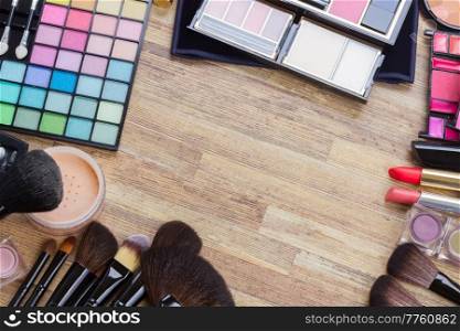 Frame of  brushes, lipsticks, maskara, eye shadows and  powder, top view . frame of make up 