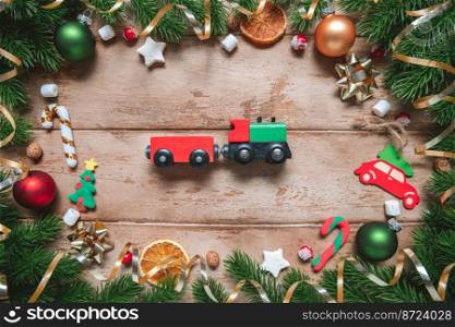 frame of Fir tree branches with Christmas decoration on wooden background, flat lay. gift, present travel. Fir tree branches with Christmas decoration on wooden background, flat lay. Space for text