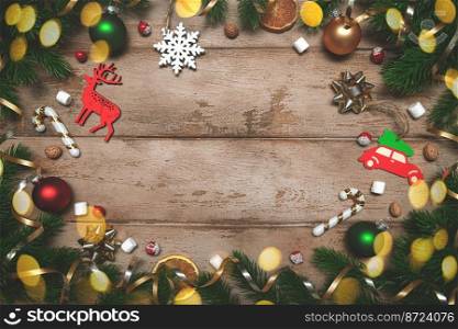 frame of Fir tree branches with Christmas decoration on wooden background, flat lay. Space for text, copy space. Fir tree branches with Christmas decoration on wooden background, flat lay