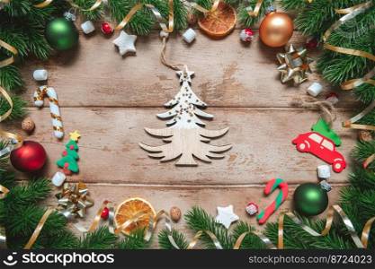 frame of Fir tree branches with Christmas decoration on wooden background, flat lay. gift, present. Fir tree branches with Christmas decoration on wooden background, flat lay. Space for text