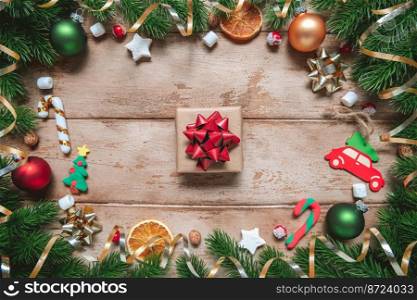 frame of Fir tree branches with Christmas decoration on wooden background, flat lay. gift, present. Fir tree branches with Christmas decoration on wooden background, flat lay. Space for text