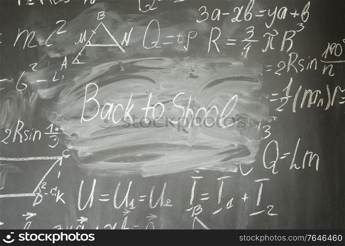 frame of formulas written in white chalk and back to school written words. math formulas on black board