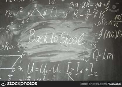 frame of formulas written in white chalk and back to school written words. math formulas on black board