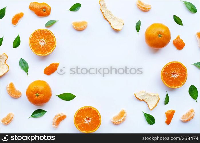 Frame of fresh orange citrus fruit with green leaves on white background.