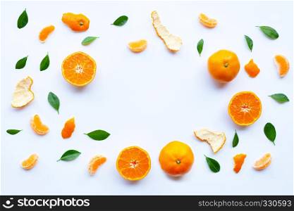 Frame of fresh orange citrus fruit with green leaves on white background.