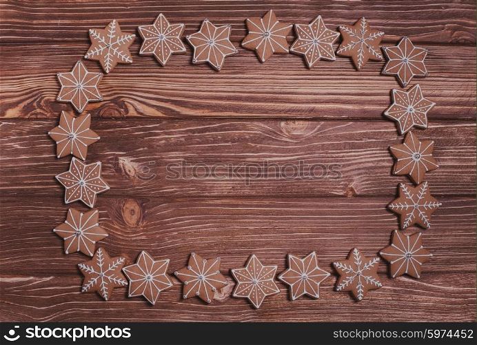Frame of gingerbreads on a wooden background.. Christmas backgrounds