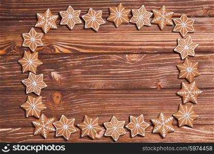 Frame of gingerbreads on a wooden background.. Christmas backgrounds