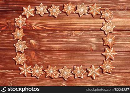 Frame of gingerbreads on a wooden background.. The Christmas backgrounds