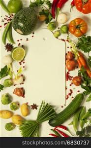 Frame of organic vegetables on white. Top view