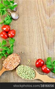 Frame of red and green lentils in a wooden spoon, tomatoes, parsley, garlic on a wooden boards background