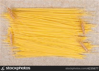 Frame of spaghetti and ears of wheat on sacking