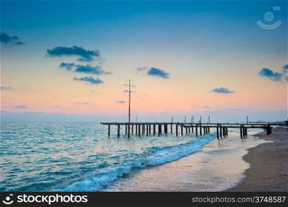 frame of the old pier on the beach at dawn