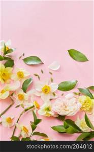 frame with flowers and leaves on a pink vertical background with space for text. Flat lay. Composition with flowers