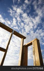 Frame wooden structure with cloudy blue sky in background.