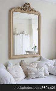 Framed mirror above daybed with cushions