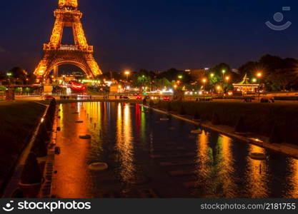 France, Paris. Tourists and cars near the Eiffel tower with night illumination. Reflections in the disabled fountain of the Trocadero Gardens. Eiffel Tower and Disabled Trocadero Fountain in the Late Evening