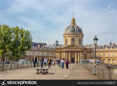 France. Summer day in Paris. People on the Footbridge of the Arts and Mazarine Library in the background. Paris Art Bridge and Mazarine Library
