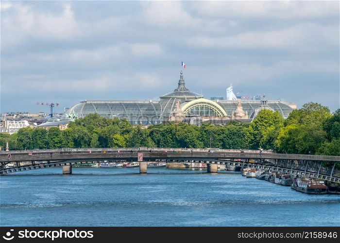 France. Summer day in Paris. The roof of the Grand Palace and residential barges are moored at the embankment of the Seine River. Grand Palace Roof and Residential Barges on the Banks of the Seine