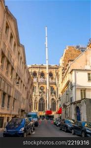France. Summer sunny day in Paris. Narrow street with parked cars. Crane restores Notre Dame after after a fire. Crane in a Narrow Street on the Restoration of Notre Dame