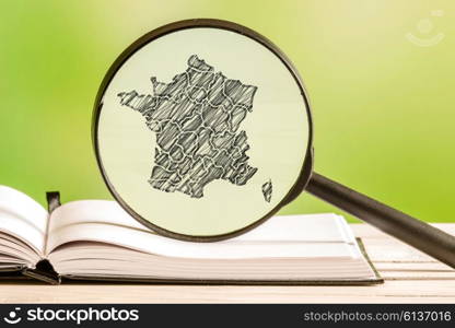 France with a pencil drawing of a french map in a magnifying glass