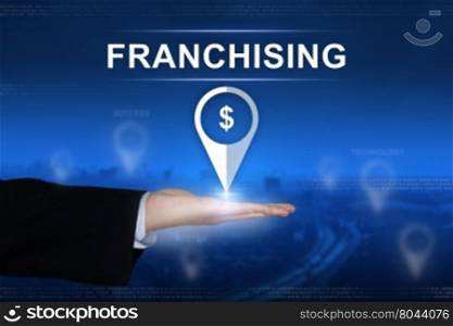 franchising button with business hand on blurred background