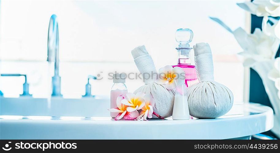 Frangipani flowers with herbal compress stamps , pink lotion bottle on luxury bath. Spa or wellness background