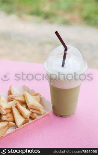 Frappe coffee and toast. Eat a snack. Coffee and bread on the table.