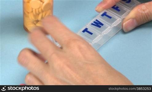 Frau sortiert Medikamente in einen PlastikbehSlter - Woman sorting pills into a plastic container - ZOOM OUT