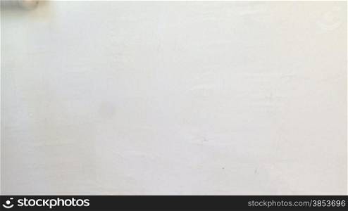 Frau verpasst einer weissen Wand einen neuen grauen Anstrich - Woman painting a wall using a roller brush