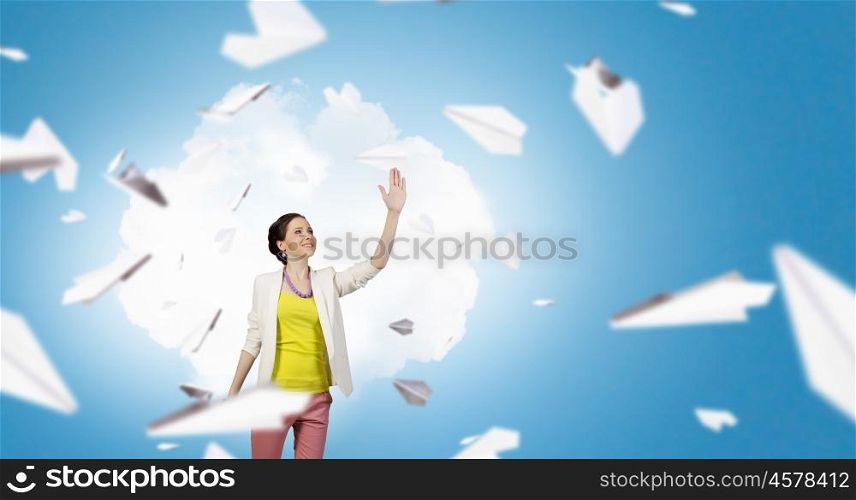 Free and careless. Young woman in casual and many paper planes flying around