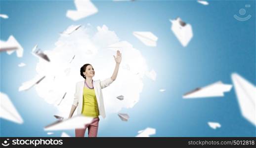 Free and careless. Young woman in casual and many paper planes flying around