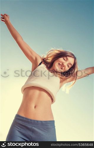 Free and happy women. Blonde teenager female jumping with the blue sky in the background