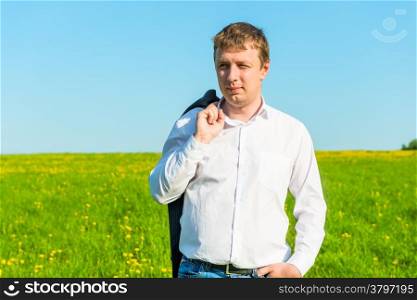 Free businessman walks on a sunny day in the field