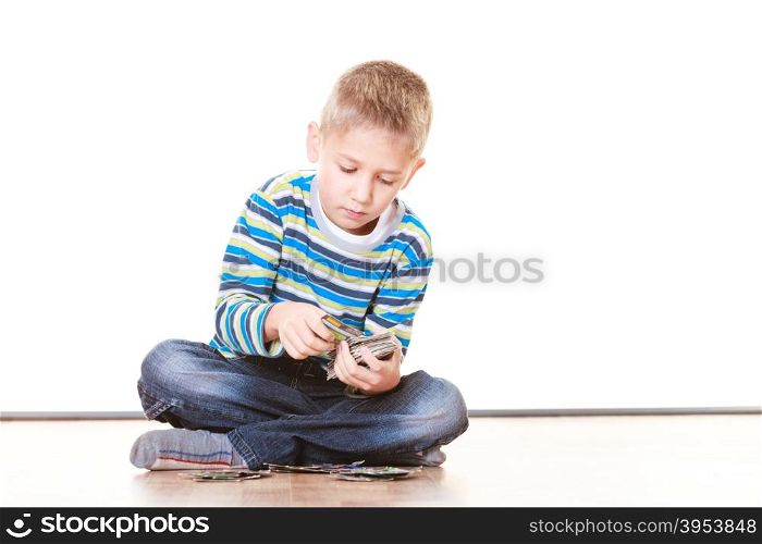 Free time, fun and hobby. Little boy play indoors sit on floor and play collect cards.