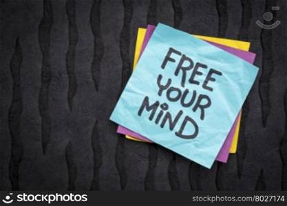 free your mind reminder note - handwriting on a sticky note against black Nepalese lokta paper