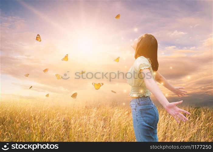 Freedom And Healthy a girl stretching her arms in the sun among the butterflies