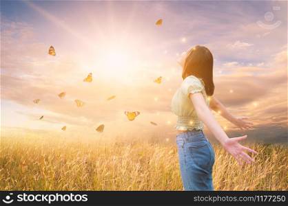 Freedom And Healthy a girl stretching her arms in the sun among the butterflies
