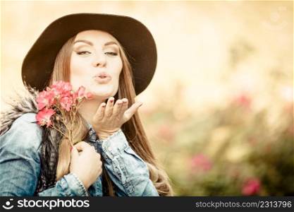 Freedom and leisure. Gorgeous adorable woman holding pink flowers. Romantic portrait of beautiful young lady blowing kiss.. Beauty woman with flowers
