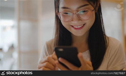 Freelance Asian women using mobile phone at office. Young Japanese Asia Girl using smartphone checking social media on the internet on the table at workplace concept.