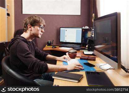 Freelance developer and designer working at home, man using desktop computer.